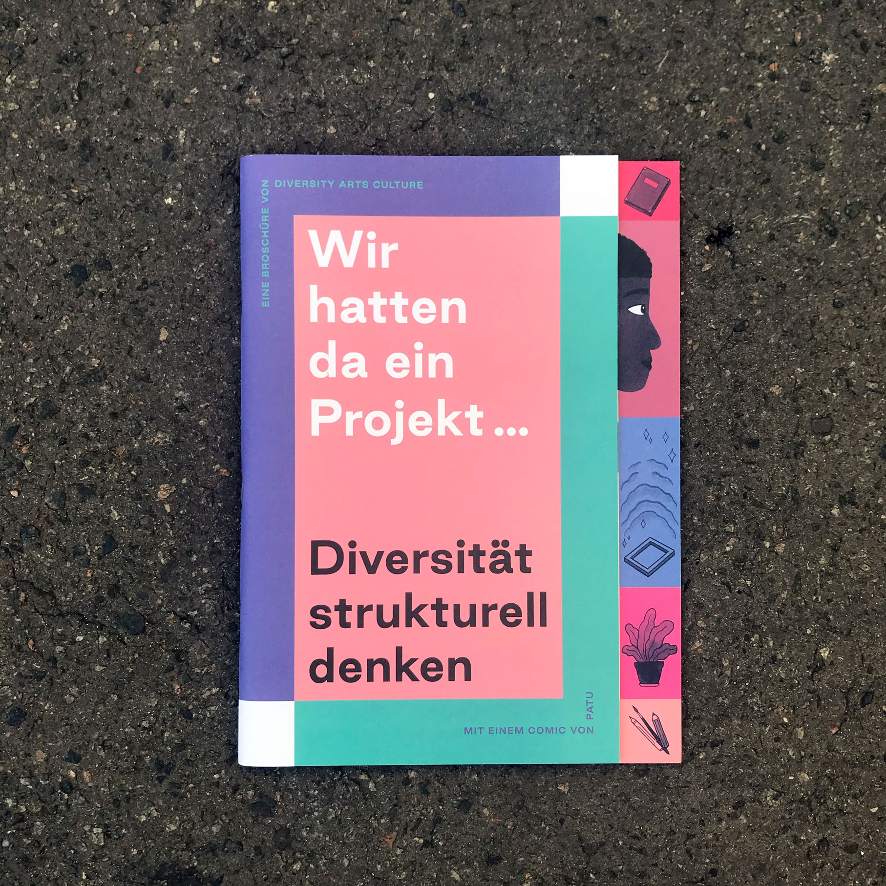 Broschüre Diversität strukturell denken Eine Broschüre liegt auf einem grauen Untergrund