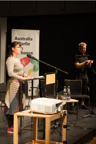 Pauline Püschel, Senatsverwaltung Kultur und Europa Pauline Püschel bei Verlesen der Begrüßung, im Hintergrund ein DGS-Dolmetscher