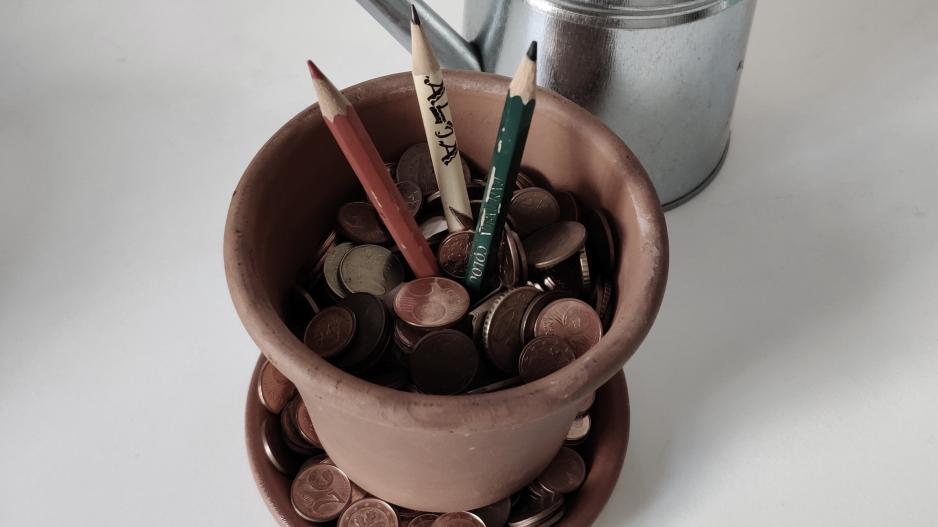 Kunst braucht Förderung zum Wachsen Drei Buntstifte wachsen in einem mit Geld gefüllten Blumentopf.