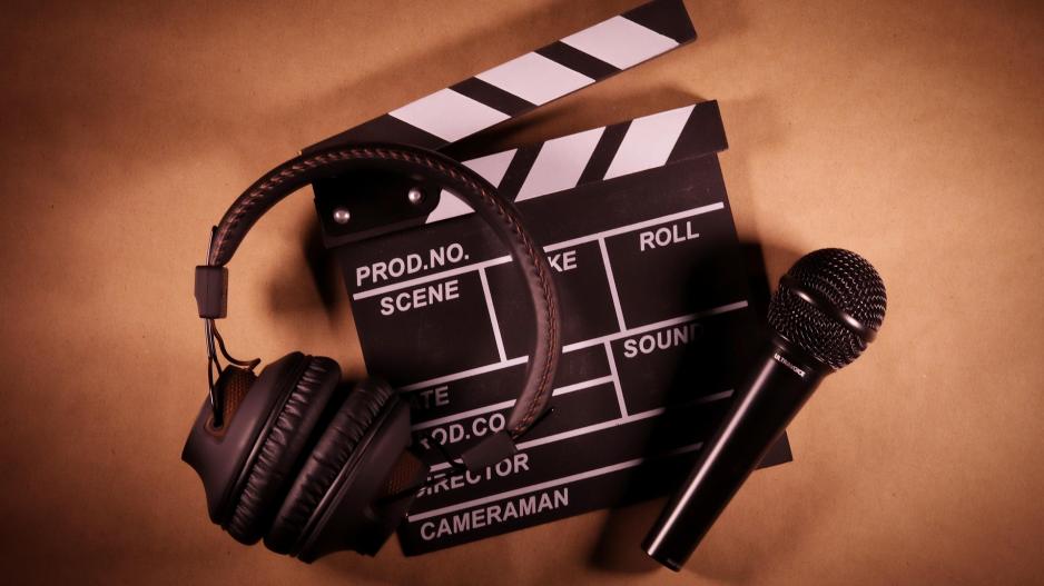 Kopfhörer, ein Mikrofon und eine Regieklappe