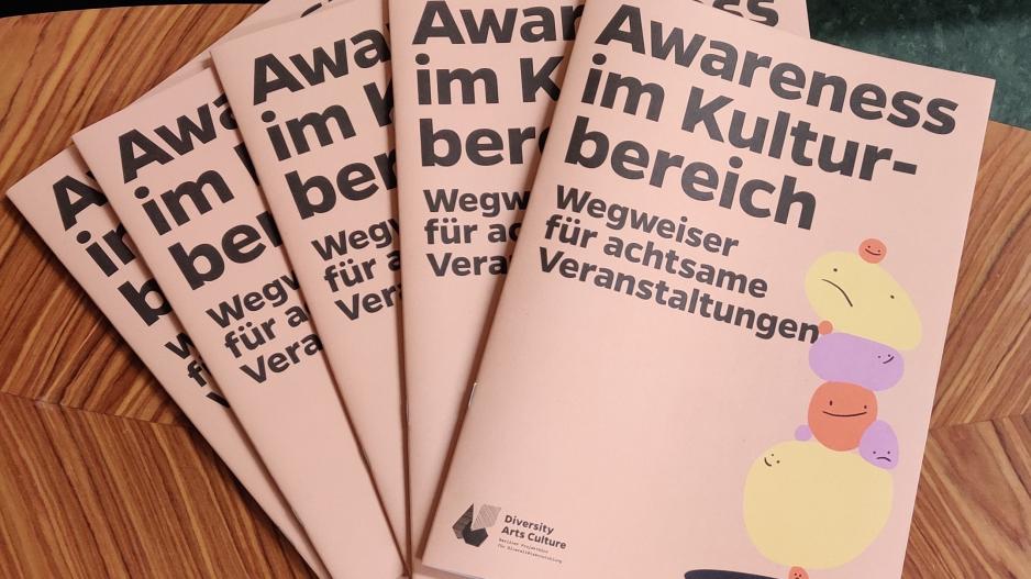 Exemplare der Printversion des Awarenessleitfadens auf einem Tisch